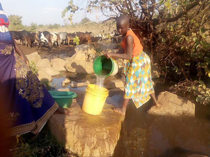 2021 02 05 Sambia Mädchen schöpft Wasser IMG 20190805 161841